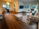 Staged living room and dining area with ample light, hardwood floors, modern seating, and decorative accents at 2111 Groveglen S Ln, Lakeland, FL 33813