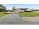 Back view of the home with driveway, lawn and additional garage in back at 2305 State Road 33 Hwy, Clermont, FL 34714