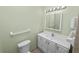 Bright bathroom featuring a toilet, vanity, sink, mirror, and towel rack at 2305 State Road 33 Hwy, Clermont, FL 34714