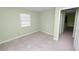 A cozy bedroom featuring tile flooring, a light green paint scheme, and a bright window at 2305 State Road 33 Hwy, Clermont, FL 34714