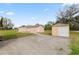 Exterior view of a home with gravel parking and storage shed in a spacious setting at 2305 State Road 33 Hwy, Clermont, FL 34714