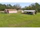 Spacious property featuring a single-Gathering home, storage shed, and a large grassy area at 2305 State Road 33 Hwy, Clermont, FL 34714