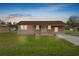 A cozy single-story home with a well-manicured lawn, illuminated by evening lighting at 2305 State Road 33 Hwy, Clermont, FL 34714