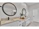 Bright bathroom with dual sinks, marble countertops, modern fixtures, and decorative round mirrors at 2985 Pickards Pass, Lakeland, FL 33813