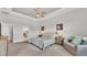 Spacious bedroom featuring tray ceiling, ceiling fan, neutral color palette, and access to ensuite bathroom at 2985 Pickards Pass, Lakeland, FL 33813