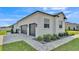 Three-car garage with gray doors and paved driveway, surrounded by manicured landscaping and green lawn at 2985 Pickards Pass, Lakeland, FL 33813