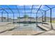 Relaxing pool within a screened enclosure features a rock waterfall wall and paved deck at 2985 Pickards Pass, Lakeland, FL 33813