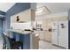 Bright kitchen with bar seating, white cabinets, and a matching refrigerator at 3203 Bear Creek Ln, Lakeland, FL 33810