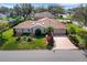 An aerial view of a home showcasing its well-kept lawn, mature trees, and long driveway at 324 Lake Mariam Blvd, Winter Haven, FL 33884