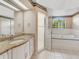 Bathroom with granite counters, white cabinets, shower, tub, tile floors, and natural light at 324 Lake Mariam Blvd, Winter Haven, FL 33884