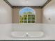 Large bathtub featuring tile surround and a garden view from the window at 324 Lake Mariam Blvd, Winter Haven, FL 33884