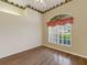 Cozy bedroom featuring wood floors, a large window, and decorative wallpaper at 324 Lake Mariam Blvd, Winter Haven, FL 33884