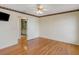 Bright bedroom featuring hardwood floors, ceiling fan, and an open doorway to the bathroom at 324 Lake Mariam Blvd, Winter Haven, FL 33884