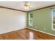 Spacious bedroom with hardwood floors, a ceiling fan, decorative wallpaper, and two large windows at 324 Lake Mariam Blvd, Winter Haven, FL 33884