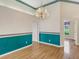 Formal dining room featuring hardwood floors, chandelier, and decorative teal accents at 324 Lake Mariam Blvd, Winter Haven, FL 33884