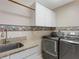 Laundry room with granite counters, sink, cabinets, washer, and dryer at 324 Lake Mariam Blvd, Winter Haven, FL 33884