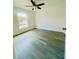 Bright bedroom featuring light gray floors, a ceiling fan, and a window letting in natural light at 3291 Alberta St, Bartow, FL 33830