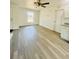 Inviting living room showcasing light gray floors, a ceiling fan, and an exterior door leading to the outside at 3291 Alberta St, Bartow, FL 33830