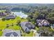 Stunning aerial view of a beautiful home with lush landscaping and a serene lake backdrop, offering peaceful living at 335 Osprey Landing Way, Lakeland, FL 33813