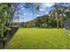 This backyard features lush green lawn, mature trees, and fencing, creating a private oasis at 335 Osprey Landing Way, Lakeland, FL 33813