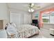 Cozy bedroom with dual closets, ceiling fan and view of window with sheer curtain at 335 Osprey Landing Way, Lakeland, FL 33813