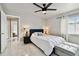 A modern bedroom with a ceiling fan and a bed that has a dark blue headboard and white comforter at 335 Osprey Landing Way, Lakeland, FL 33813