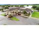 Aerial view of a building exterior showcasing a covered entrance, elegant design, and lush landscaping near a lake and golf course at 335 Osprey Landing Way, Lakeland, FL 33813