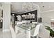 A dining area features a glass table with white chairs and a stunning chandelier hanging above at 335 Osprey Landing Way, Lakeland, FL 33813