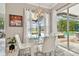 Bright dining room with chandelier over glass table, white chairs and view of pool area at 335 Osprey Landing Way, Lakeland, FL 33813