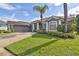 Charming one-story home featuring a gray exterior, a well-manicured lawn, and a driveway leading to a two-car garage at 335 Osprey Landing Way, Lakeland, FL 33813