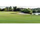 Scenic view of a lush green golf course with sand traps and a picturesque pond at 335 Osprey Landing Way, Lakeland, FL 33813