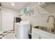 Laundry room featuring a white washer, sink, storage shelves and checkered floor at 335 Osprey Landing Way, Lakeland, FL 33813