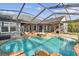 Gorgeous screened-in pool area with spa and outdoor kitchen, ideal for relaxation and entertaining at 335 Osprey Landing Way, Lakeland, FL 33813