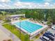 Aerial view of a large, inviting swimming pool with ample seating, surrounded by trees and a golf course at 335 Osprey Landing Way, Lakeland, FL 33813