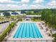 Overhead view of a beautiful swimming pool featuring lounge chairs, tables, umbrellas, and an adjacent golf course at 335 Osprey Landing Way, Lakeland, FL 33813