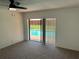 Bedroom with ceiling fan, carpet, and sliding glass doors leading to private pool area at 362 Pasco Ct, Winter Haven, FL 33884