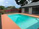 Inviting backyard pool with a safety fence, covered patio, and mature trees for shade at 362 Pasco Ct, Winter Haven, FL 33884