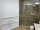 Shower featuring decorative tile, glass door, rainfall shower head, built in shelving at 362 Pasco Ct, Winter Haven, FL 33884