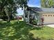 Side view of a home with well maintained lawn and mature landscaping around the foundation at 362 Pasco Ct, Winter Haven, FL 33884