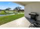 An inviting back patio with a BBQ grill, overlooking a scenic pond and lush green lawn at 3862 Willow Ridge Dr, Lakeland, FL 33810