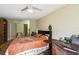 Bedroom with ceiling fan, wood floors, and view to en-suite bathroom at 3901 Oak Loop # 33, Mulberry, FL 33860