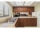 Well-lit kitchen features wood cabinets, stainless steel sink, and countertop appliances at 3901 Oak Loop # 33, Mulberry, FL 33860