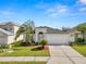 Exterior shot of the home showcasing the garage, front door, and well maintained lawn at 3961 Hampton Hills W Dr, Lakeland, FL 33810