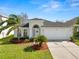 Lovely home featuring a manicured lawn, complemented by mature landscaping and a convenient two-car garage at 3961 Hampton Hills W Dr, Lakeland, FL 33810