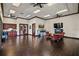 A spacious amenity room featuring wood floors, ceiling fans, skylights, kitchenette, fireplace, and comfortable seating at 4002 Sunset Lake Dr, Lakeland, FL 33810