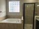 Bathroom with large bathtub, tiled walls, and glass block window allowing natural light at 4002 Sunset Lake Dr, Lakeland, FL 33810