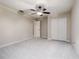 Neutral bedroom featuring ceiling fan, closet, and doorway leading to additional rooms at 4002 Sunset Lake Dr, Lakeland, FL 33810