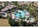 Aerial view of the community pool area boasting a large pool, spa, splashpad, and lush landscaping with picnic area at 4002 Sunset Lake Dr, Lakeland, FL 33810