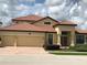 Charming home featuring a red-tiled roof, brick driveway, and a spacious two-car garage at 4002 Sunset Lake Dr, Lakeland, FL 33810