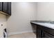 Functional laundry room with granite countertop and black cabinets at 4002 Sunset Lake Dr, Lakeland, FL 33810